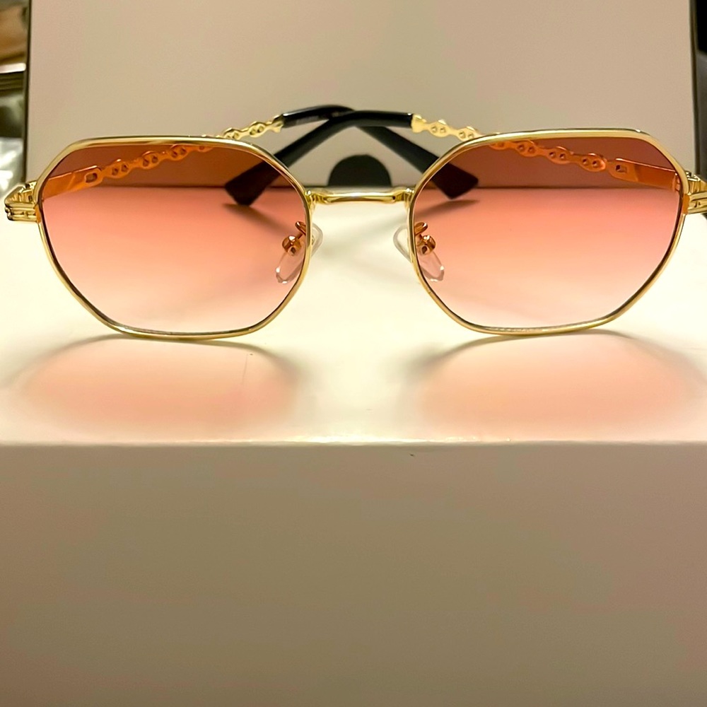 Gold metal octagon frame sunglasses with pink lenses